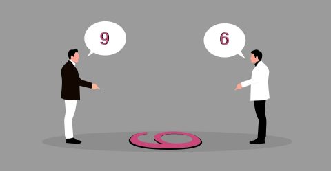 Zwei Personen schauen auf eine auf dem Boden liegende 6 bzw. 9.